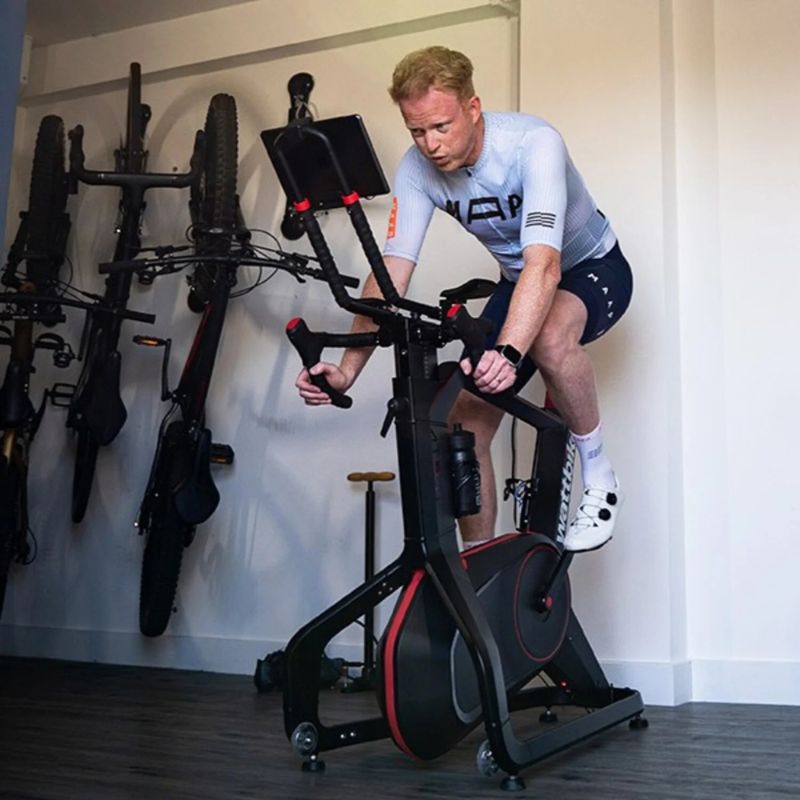 Wattbike Atom 2025 exercise bike man riding the bike in the garage
